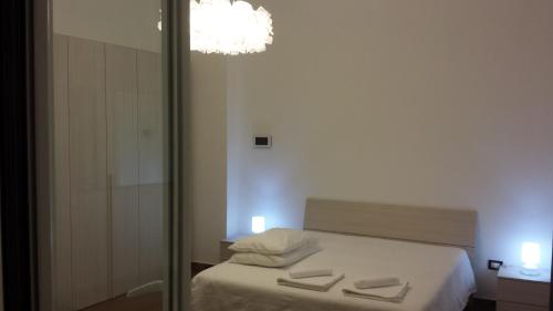 Dormitorio con cama con espejo y lámpara de araña en Peri Peri Holiday Home - Siracusa, en Solarino