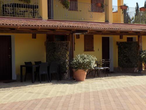 a patio with a table and chairs and a plant at Villa Sorrentina in Alghero