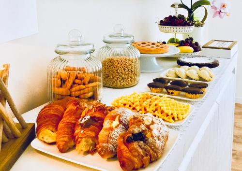 een tafel met verschillende soorten gebak en desserts bij Flowers Sweet Rooms B&B in Vasto