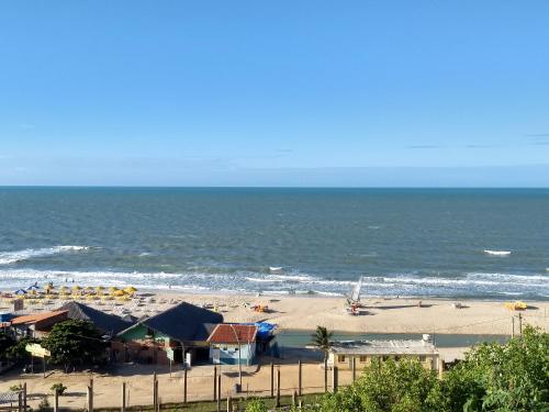 a beach with chairs and umbrellas and the ocean at Pousada Familiar Beberibe in Beberibe