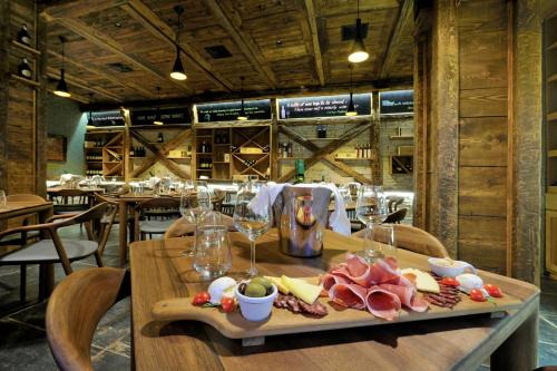 a table with a tray of meat and wine glasses at Ethno Houses Plitvice Lakes Hotel in Plitvica selo