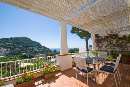 a patio with a table and chairs on a balcony at Carthusia Suites in Capri