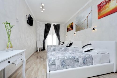 a white bedroom with a bed and a desk at Just Chilling Suite in Rome