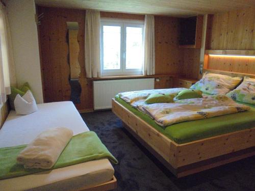 1 Schlafzimmer mit 2 Einzelbetten und einem Fenster in der Unterkunft Ferienhaus Nussbaumer in Sibratsgfäll