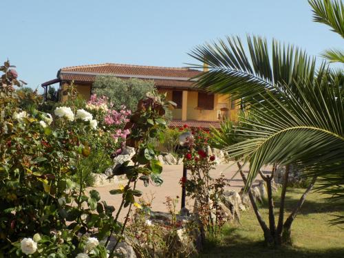 a house with a lot of flowers in front of it at Villa Sorrentina in Alghero
