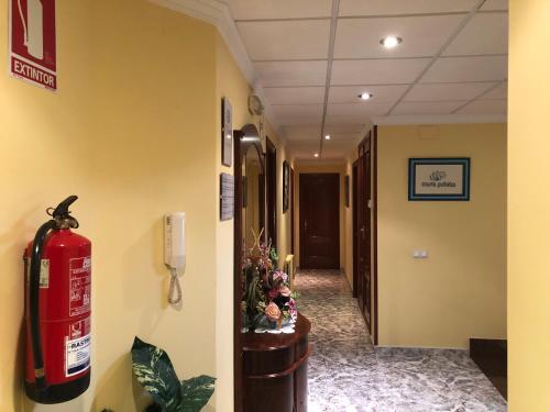 a fire extinguisher on the wall of a hallway at Pension Casa Prieto in Villalonga