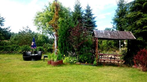 a garden with a gazebo in the grass at Willa Zamkowisko z ogrodowym jacuzzi in Gołubie