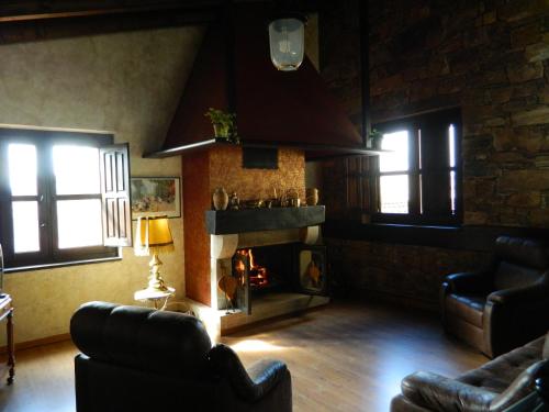 a living room with a fireplace and two couches at Posada De Gaspar in Rabanal del Camino