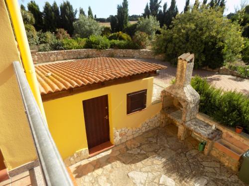 a yellow house with a tile roof at Villa Sorrentina in Alghero