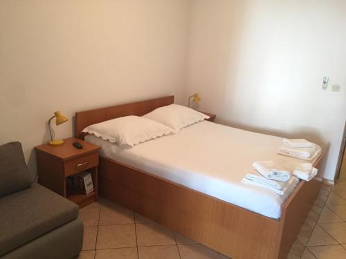 - une petite chambre avec un lit et une chaise dans l'établissement Apartments Juric, à Baška Voda