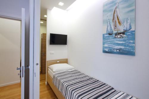 a bedroom with a bed and a painting of sailboats at Dream Hotel in Velika Gorica