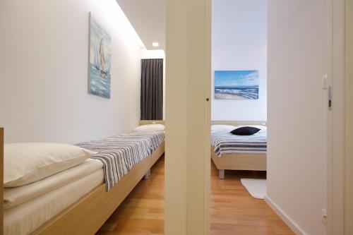 a small bedroom with two beds and a door to another room at Dream Hotel in Velika Gorica