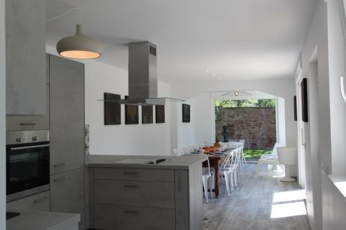 a white kitchen with a table and a dining room at Subtil insolite in Colmar