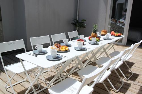 a white table and chairs with food on it at Subtil insolite in Colmar