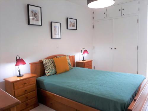 クアルテイラにあるSol europa- Vista Mar, 150mt Praia, Wifiのベッドルーム1室(ベッド1台、ドレッサーのランプ2つ付)