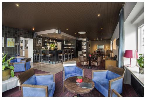 ein Restaurant mit blauen Stühlen, einem Tisch und einer Bar in der Unterkunft Hotel Ter Streep in Ostende