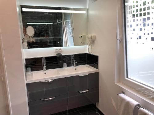 a bathroom with a sink and a mirror at Le Beverl'inn in Flers