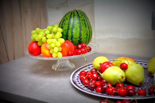 a table with a bowl of fruit and a bowl of watermelon at Vasilicos Sea Stay in Paralia Katerinis
