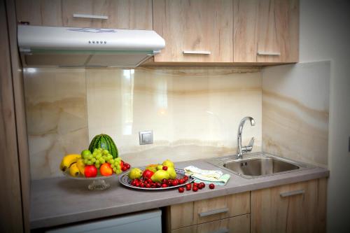 a kitchen counter with a bowl of fruit and a sink at Vasilicos Sea Stay in Paralia Katerinis