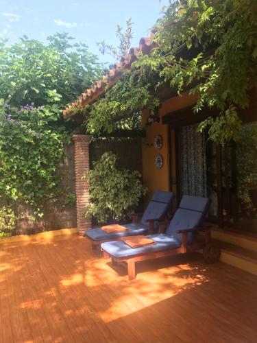 a patio with two blue benches on a wooden deck at Family hotel Al- Ana Marbella in Estepona