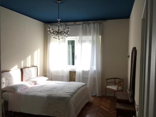 a bedroom with a bed and a chandelier and a window at Beaucoeur in Aosta