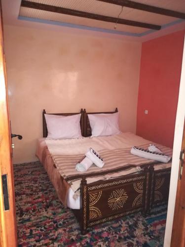 a bedroom with a bed with two remote controls on it at Berber Family Lodge in Imlil