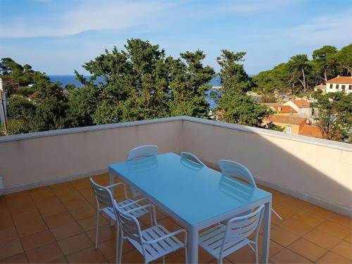 a blue table and chairs on a balcony at Buganvilija C6 in Veli Lošinj