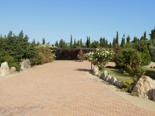a brick path in a garden with flowers and trees at Villa Sorrentina in Alghero