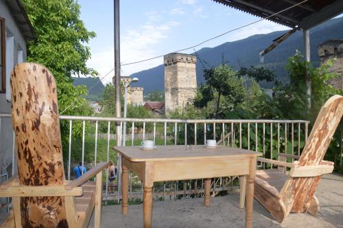 a wooden table and two chairs on a balcony at Ailama Guesthouse in Mestia