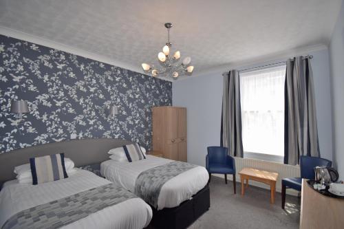 a hotel room with two beds and a chandelier at The Babbacombe Hotel in Torquay