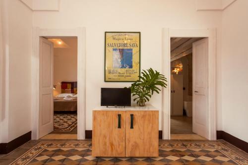 a living room with a tv on a wooden cabinet at Villa Colittacarrafa in Galatone