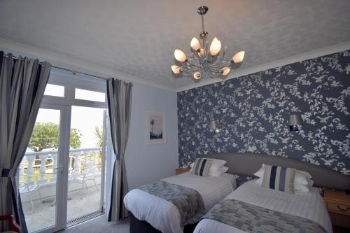 a bedroom with two beds and a chandelier at The Babbacombe Hotel in Torquay