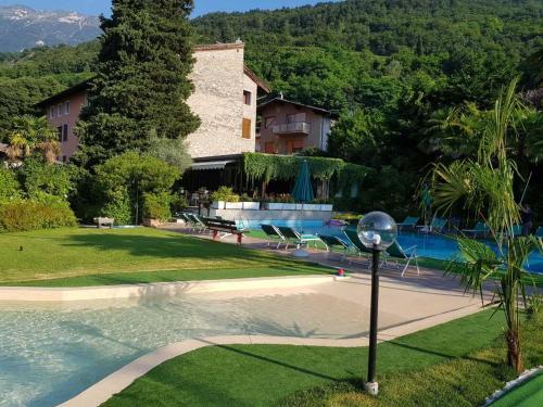 a resort with a swimming pool and a building at Residence Concaverde in Pomarolo