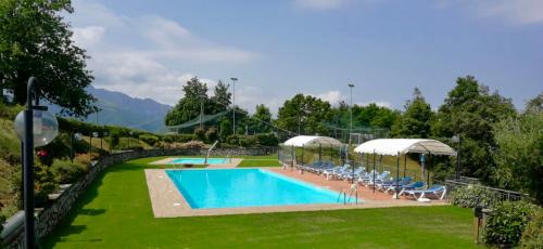 - une grande piscine dans une cour avec des chaises longues dans l'établissement Hotel Belvedere, à Minucciano