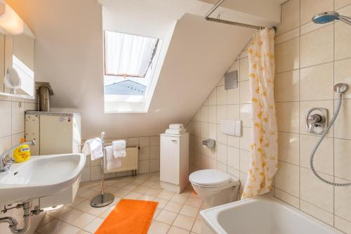 a bathroom with a sink toilet and a window at Ferienwohnungen Haus Christine in Lindau