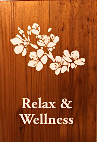 a sign with white flowers on a wooden wall at ALL'ALBARO AGRITURISMO in Salizzole