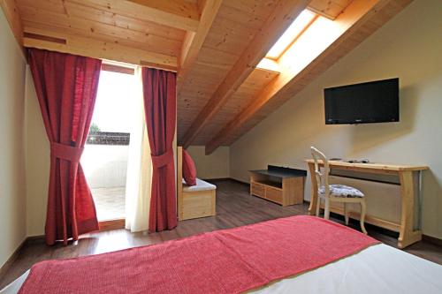 a bedroom with a bed and a desk and a television at ALL'ALBARO AGRITURISMO in Salizzole