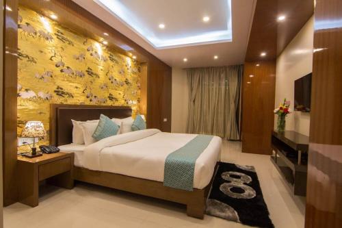 um quarto com uma cama grande e uma televisão. em HOTEL HEIGA vns em Shillong