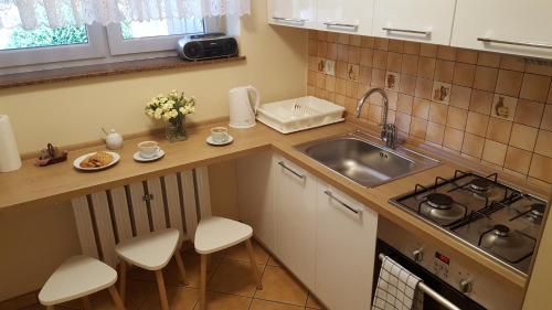 a kitchen with a sink and a stove and a counter at Dom Gościnny Korab in Kołobrzeg