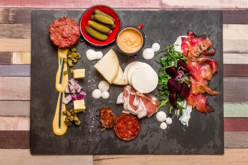 a plate of food with meat and cheese and vegetables at Mercure Budapest City Center in Budapest