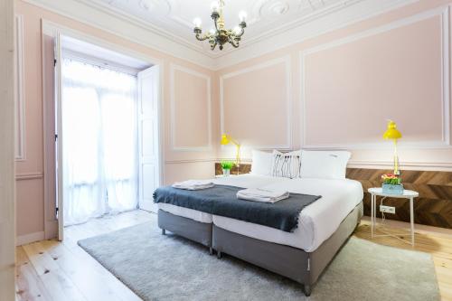 リスボンにあるFLH Marquês Trendy Apartmentのベッドルーム1室(大型ベッド1台、シャンデリア付)