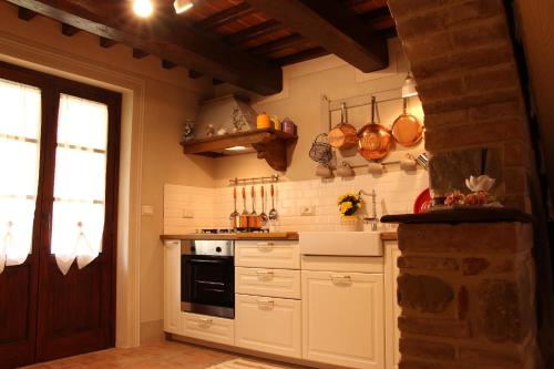 kuchnia z białymi szafkami i czarnym piekarnikiem w obiekcie Il Cortile delle Rose Holiday House w mieście Perugia
