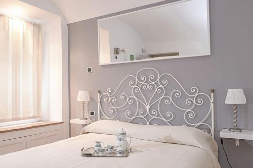 um quarto branco com uma cama com uma cabeceira de cama prateada em Sweet Rome Colosseo em Roma