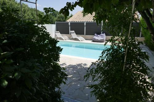 una piscina con 2 tumbonas junto a ella en Les Hauts De Reillanne en Reillanne