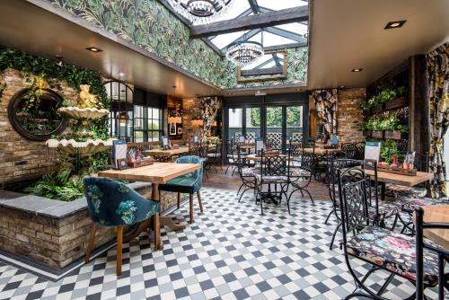 a restaurant with tables and chairs and a ceiling at The Seaton Lane Inn - The Inn Collection Group in Seaham