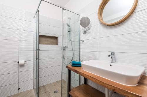 a bathroom with a sink and a glass shower at Apartments Linda in Mošćenička Draga
