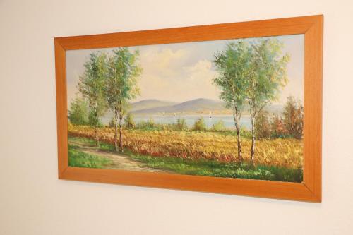 a painting of a field with trees on a wall at Hotel Lowen in Walenstadt