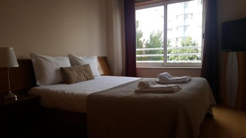 a hotel room with a bed with two towels on it at Lisbon Location in Lisbon