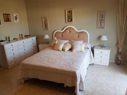 ロス・バリオスにあるCasa Chalet Las Cameliasのベッドルーム1室(大型ベッド1台、ドレッサー2台付)