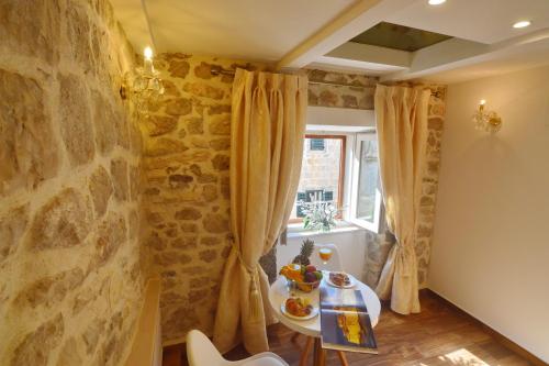 a room with a stone wall and a table and a window at Villa Madonna della Strada A5 in Dubrovnik